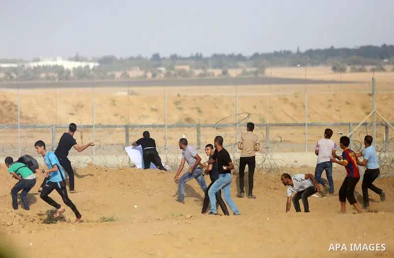 Palestinian protesters gather during clashes with Israeli troops in tents protest where Palestinian demand the right to return to their homeland at the Israel-Gaza border, in Khan Younis, in the southern Gaza Strip on Au...