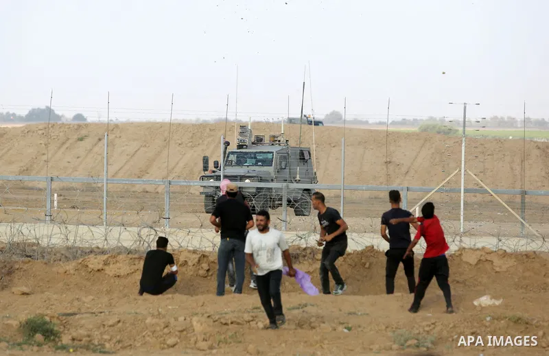Palestinian protesters gather during clashes with Israeli troops in tents protest where Palestinian demand the right to return to their homeland at the Israel-Gaza border, in Khan Younis, in the southern Gaza Strip on Au...