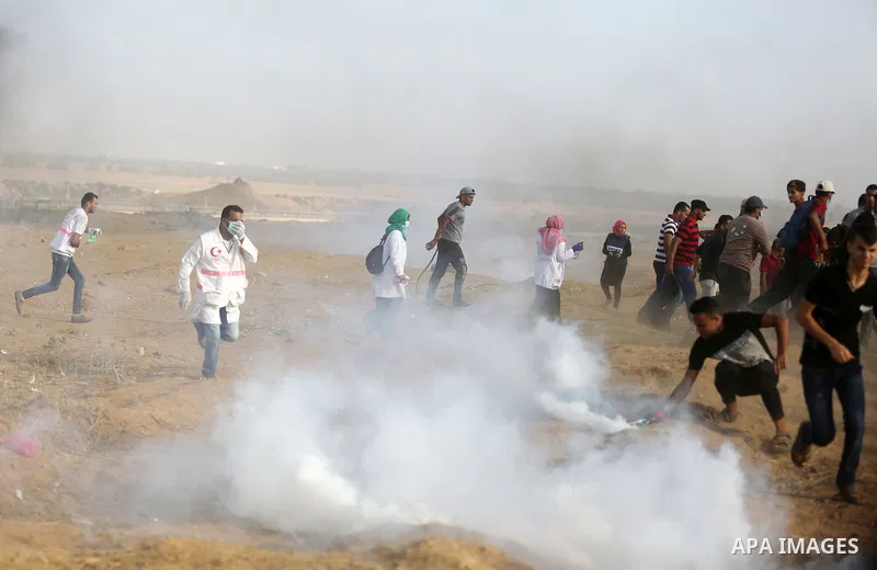 Palestinian protesters gather during clashes with Israeli troops in tents protest where Palestinian demand the right to return to their homeland at the Israel-Gaza border, in Khan Younis, in the southern Gaza Strip on Au...