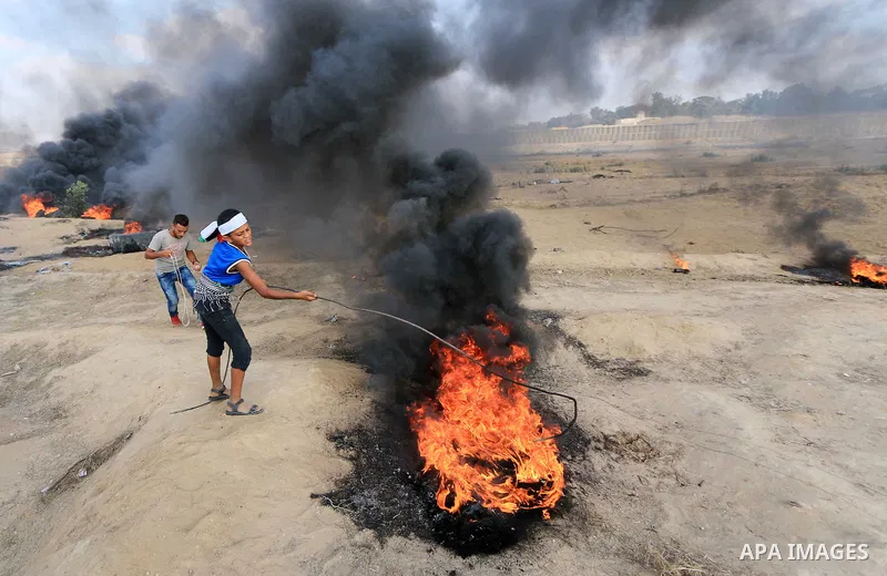 Palestinian protesters gather during clashes with Israeli troops in tents protest where Palestinian demand the right to return to their homeland at the Israel-Gaza border, in al-Bureij, in the center of Gaza Strip on Aug...