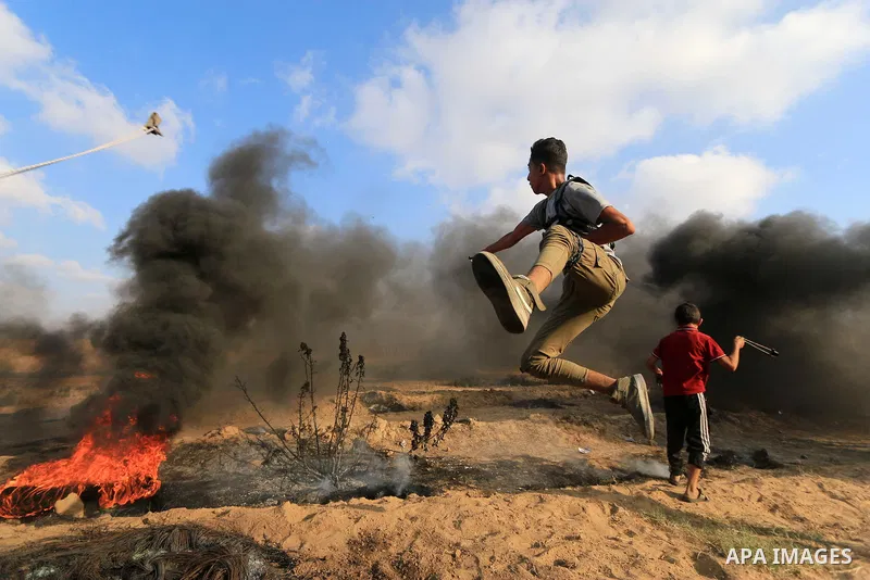 Palestinian protesters gather during clashes with Israeli troops in tents protest where Palestinian demand the right to return to their homeland at the Israel-Gaza border, in al-Bureij, in the center of Gaza Strip on Aug...