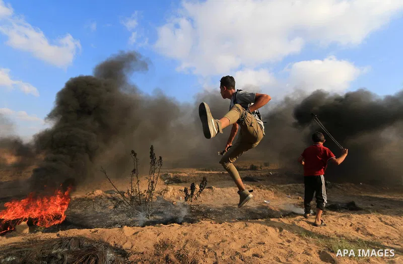 Palestinian protesters gather during clashes with Israeli troops in tents protest where Palestinian demand the right to return to their homeland at the Israel-Gaza border, in al-Bureij, in the center of Gaza Strip on Aug...