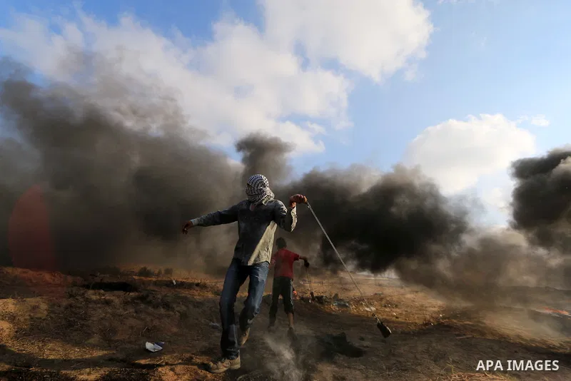 Palestinian protesters gather during clashes with Israeli troops in tents protest where Palestinian demand the right to return to their homeland at the Israel-Gaza border, in al-Bureij, in the center of Gaza Strip on Aug...