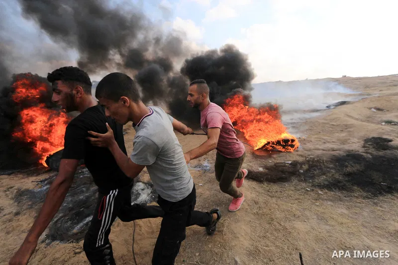 Palestinian protesters gather during clashes with Israeli troops in tents protest where Palestinian demand the right to return to their homeland at the Israel-Gaza border, in al-Bureij, in the center of Gaza Strip on Aug...