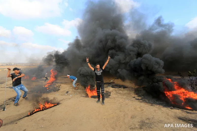 Palestinian protesters gather during clashes with Israeli troops in tents protest where Palestinian demand the right to return to their homeland at the Israel-Gaza border, in al-Bureij, in the center of Gaza Strip on Aug...
