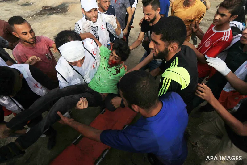A wounded Palestinian protester is evacuated during clashes with Israeli troops in tents protest where Palestinian demand the right to return to their homeland at the Israel-Gaza border, in al-Bureij, in the center of Ga...