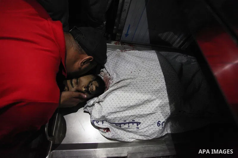 Relatives of Palestinian Ahmed Yaghi, 25, who was shot dead by Israeli troops during clashes at Gaza-Israel border mourn over his body at a morgue in a hospital in Gaza city on Aug. 03, 2018. Photo by Mahmoud Ajour