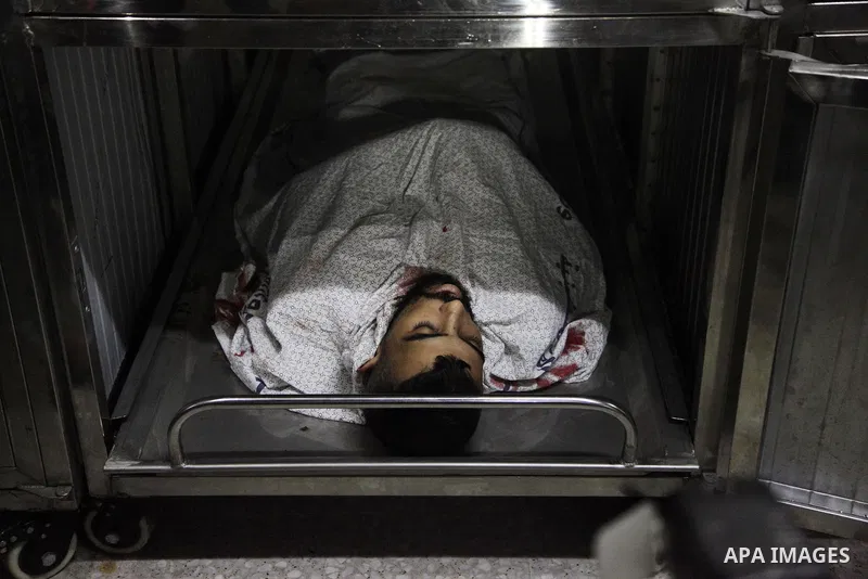 Relatives of Palestinian Ahmed Yaghi, 25, who was shot dead by Israeli troops during clashes at Gaza-Israel border mourn over his body at a morgue in a hospital in Gaza city on Aug. 03, 2018. Photo by Mahmoud Ajour
