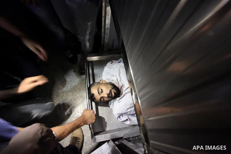 Relatives of Palestinian Ahmed Yaghi, 25, who was shot dead by Israeli troops during clashes at Gaza-Israel border mourn over his body at a morgue in a hospital in Gaza city on Aug. 03, 2018. Photo by Mahmoud Ajour