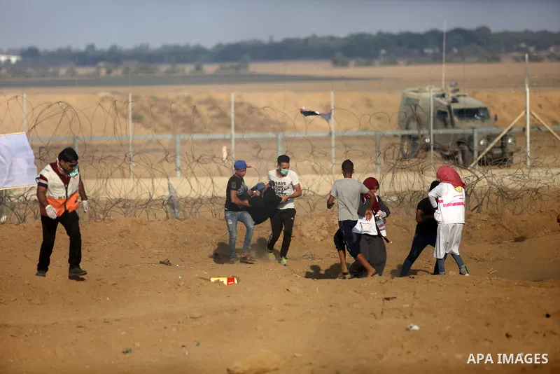 Palestinian protesters gather during clashes with Israeli troops in tents protest where Palestinian demand the right to return to their homeland at the Israel-Gaza border, in Khan Younis, in the southern Gaza Strip on Au...