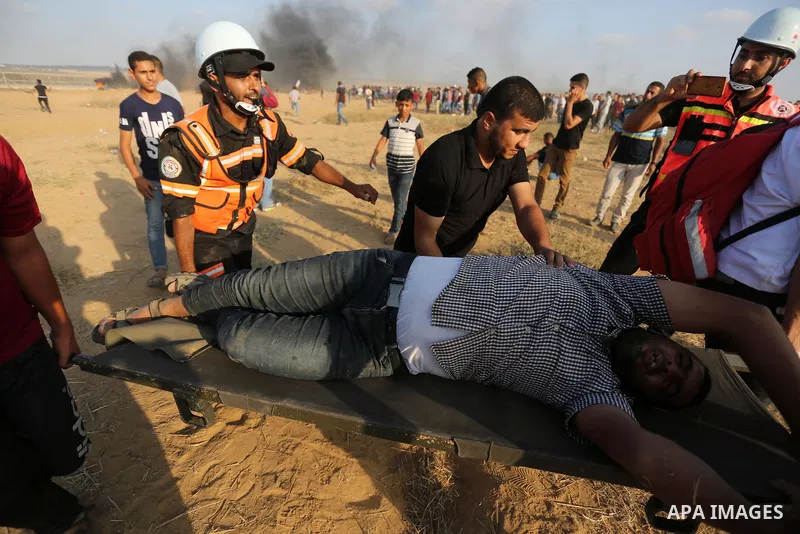 Palestinian protesters gather during clashes with Israeli troops in tents protest where Palestinian demand the right to return to their homeland at the Israel-Gaza border, in Khan Younis, in the southern Gaza Strip on Au...
