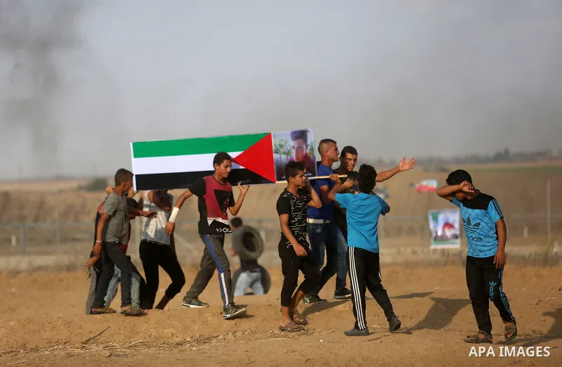 Palestinian protesters gather during clashes with Israeli troops in tents protest where Palestinian demand the right to return to their homeland at the Israel-Gaza border, in Khan Younis, in the southern Gaza Strip on Au...