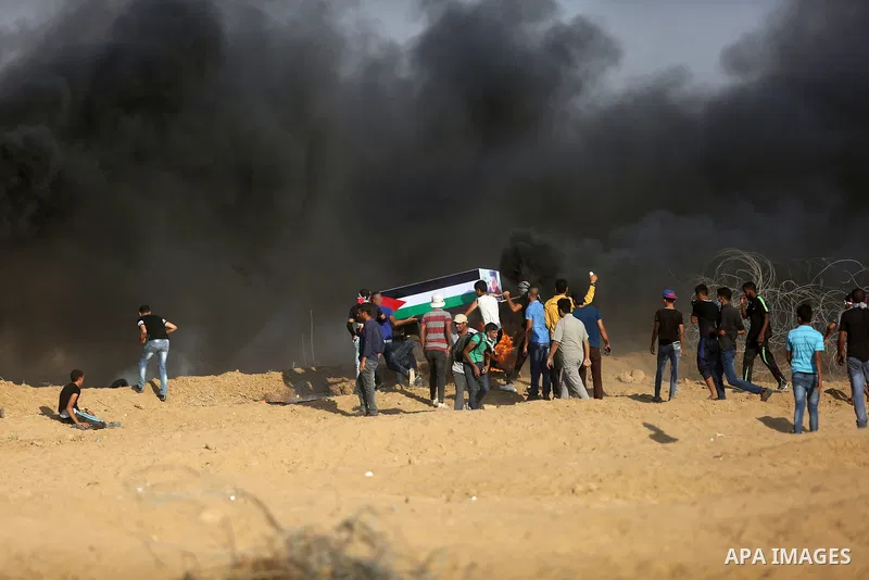 Palestinian protesters gather during clashes with Israeli troops in tents protest where Palestinian demand the right to return to their homeland at the Israel-Gaza border, in Khan Younis, in the southern Gaza Strip on Au...
