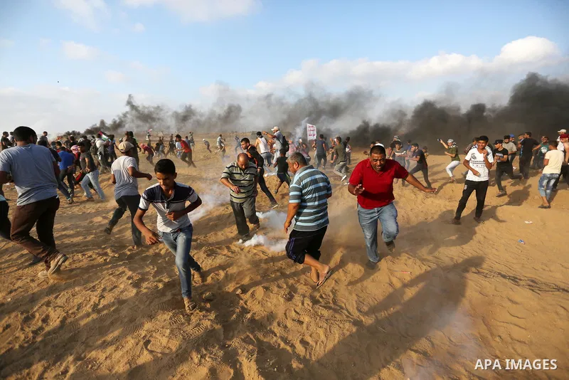 Palestinian protesters gather during clashes with Israeli troops in tents protest where Palestinian demand the right to return to their homeland at the Israel-Gaza border, in Khan Younis, in the southern Gaza Strip on Au...