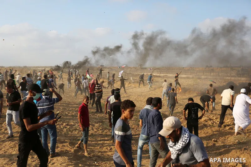 Palestinian protesters gather during clashes with Israeli troops in tents protest where Palestinian demand the right to return to their homeland at the Israel-Gaza border, in Khan Younis, in the southern Gaza Strip on Au...