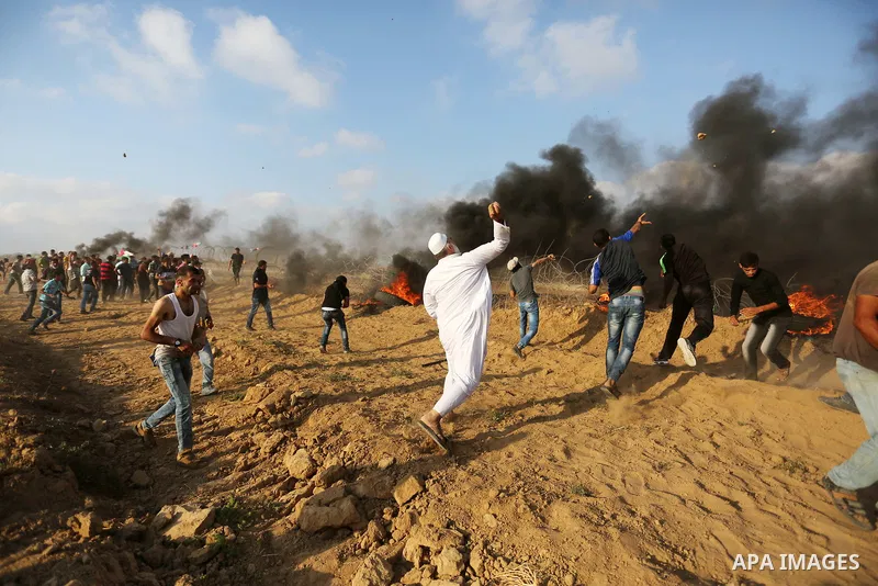 Palestinian protesters gather during clashes with Israeli troops in tents protest where Palestinian demand the right to return to their homeland at the Israel-Gaza border, in Khan Younis, in the southern Gaza Strip on Au...