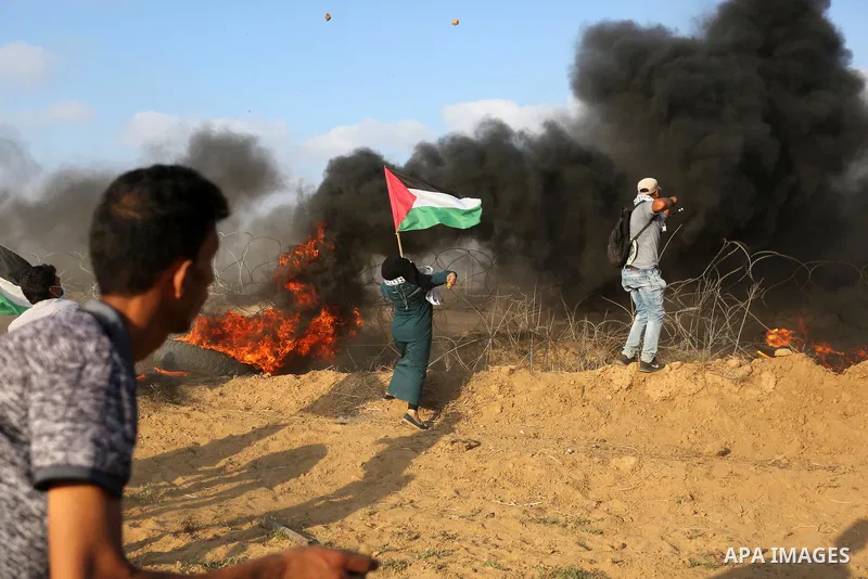 Palestinian protesters gather during clashes with Israeli troops in tents protest where Palestinian demand the right to return to their homeland at the Israel-Gaza border, in Khan Younis, in the southern Gaza Strip on Au...