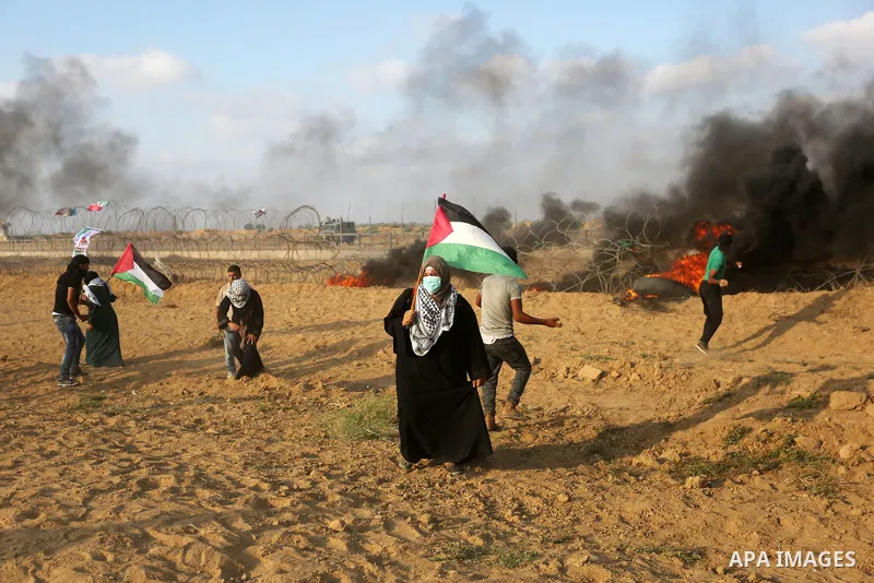Palestinian protesters gather during clashes with Israeli troops in tents protest where Palestinian demand the right to return to their homeland at the Israel-Gaza border, in Khan Younis, in the southern Gaza Strip on Au...