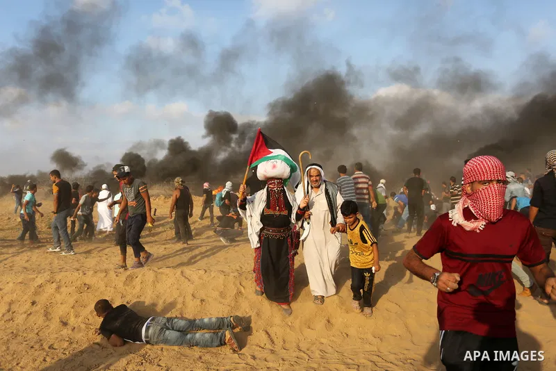 Palestinian protesters gather during clashes with Israeli troops in tents protest where Palestinian demand the right to return to their homeland at the Israel-Gaza border, in Khan Younis, in the southern Gaza Strip on Au...
