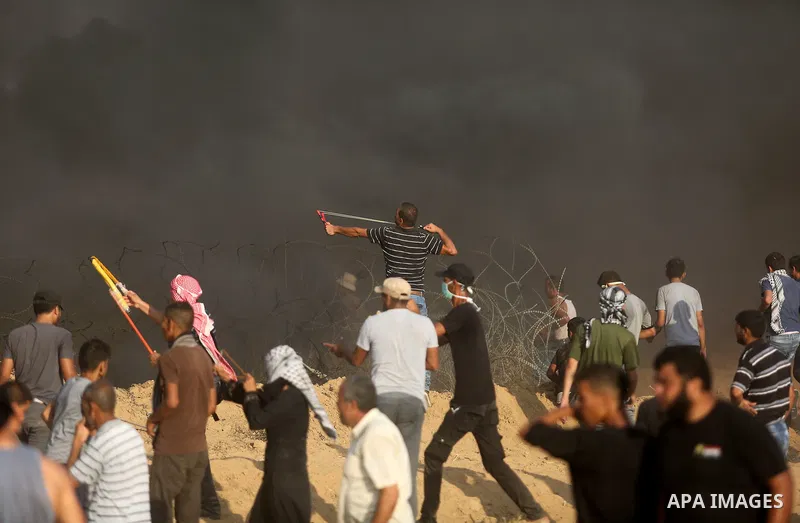 Palestinian protesters gather during clashes with Israeli troops in tents protest where Palestinian demand the right to return to their homeland at the Israel-Gaza border, in Khan Younis, in the southern Gaza Strip on Au...