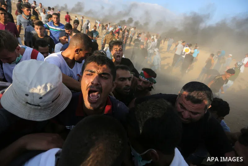 Palestinian protesters gather during clashes with Israeli troops in tents protest where Palestinian demand the right to return to their homeland at the Israel-Gaza border, in Khan Younis, in the southern Gaza Strip on Au...
