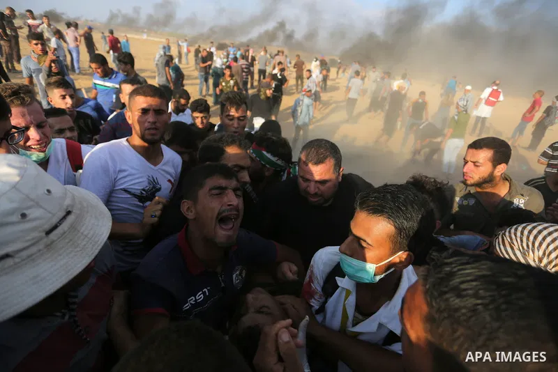 Palestinian protesters gather during clashes with Israeli troops in tents protest where Palestinian demand the right to return to their homeland at the Israel-Gaza border, in Khan Younis, in the southern Gaza Strip on Au...