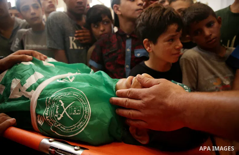 Relatives of Palestinian teenager Moath Al-Sori, who died from wounds suffered during clashes with Israeli troops along the border the previous day, mourn over his body during his funeral in Nusairat in the center of Gaz...