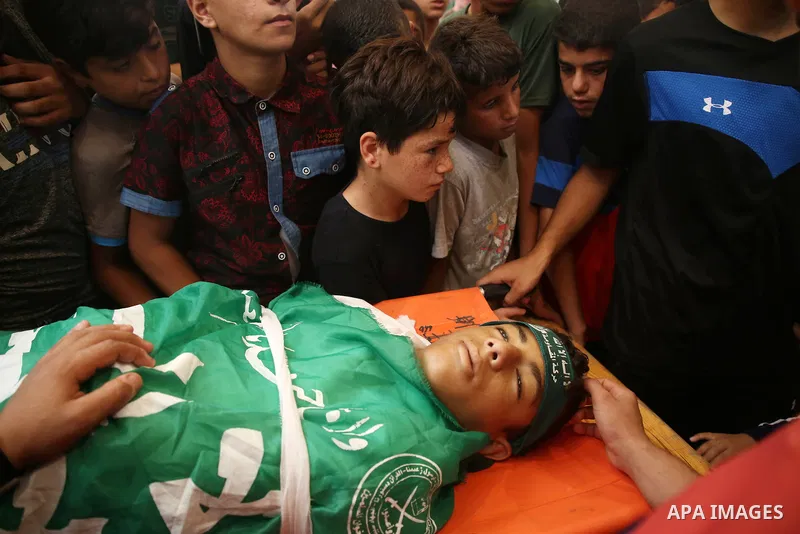Relatives of Palestinian teenager Moath Al-Sori, who died from wounds suffered during clashes with Israeli troops along the border the previous day, mourn over his body during his funeral in Nusairat in the center of Gaz...
