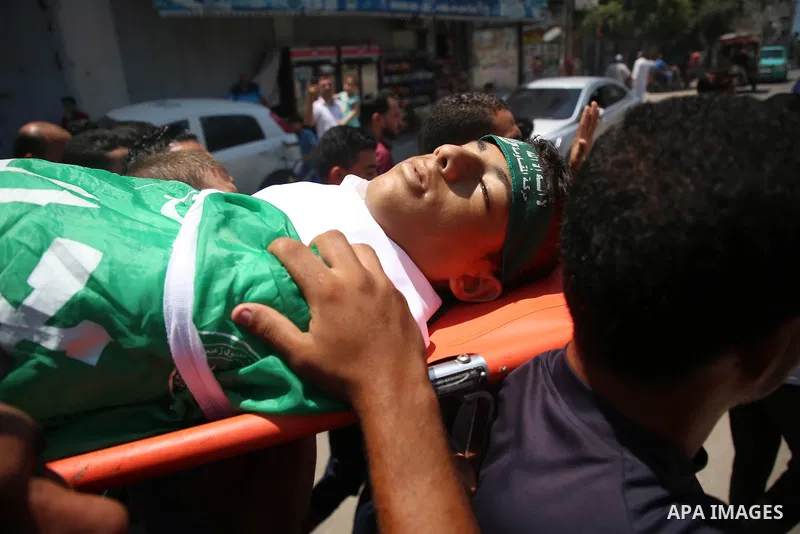 Mourners carry the body of Palestinian teenager Moath Al-Sori, who died from wounds suffered during clashes with Israeli troops along the border the previous day, during his funeral in Nusairat in the center of Gaza Stri...