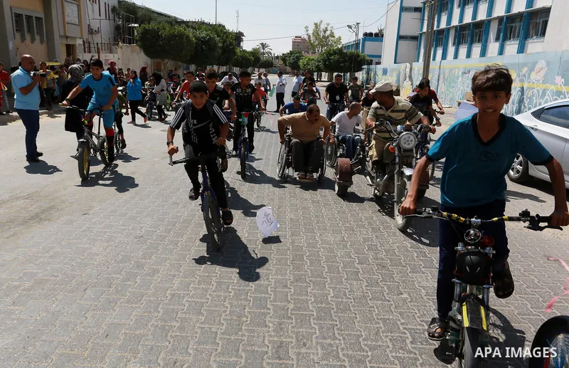 Palestinian children ride bicycles during a marathon in conjunction with a marathon in Britain, Australia, Luton, Birmingham and Coventry to support Palestinian's children and against weapon finance to Israel, in Rafah i...