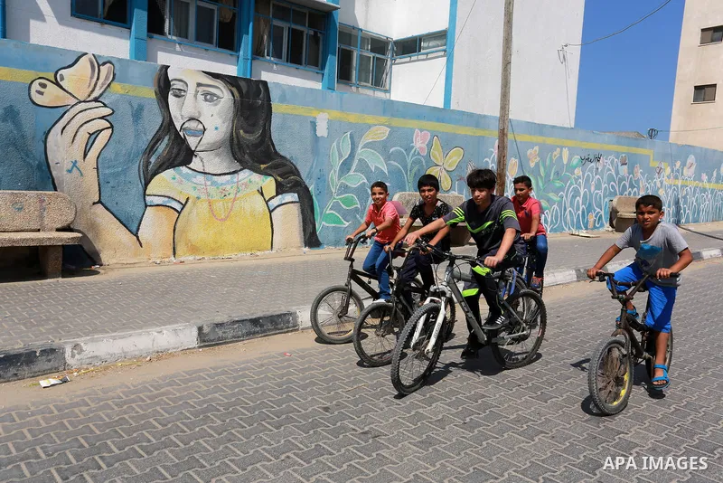 Palestinian children ride bicycles during a marathon in conjunction with a marathon in Britain, Australia, Luton, Birmingham and Coventry to support Palestinian's children and against weapon finance to Israel, in Rafah i...