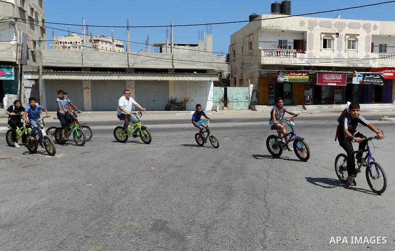 Palestinian children ride bicycles during a marathon in conjunction with a marathon in Britain, Australia, Luton, Birmingham and Coventry to support Palestinian's children and against weapon finance to Israel, in Rafah i...