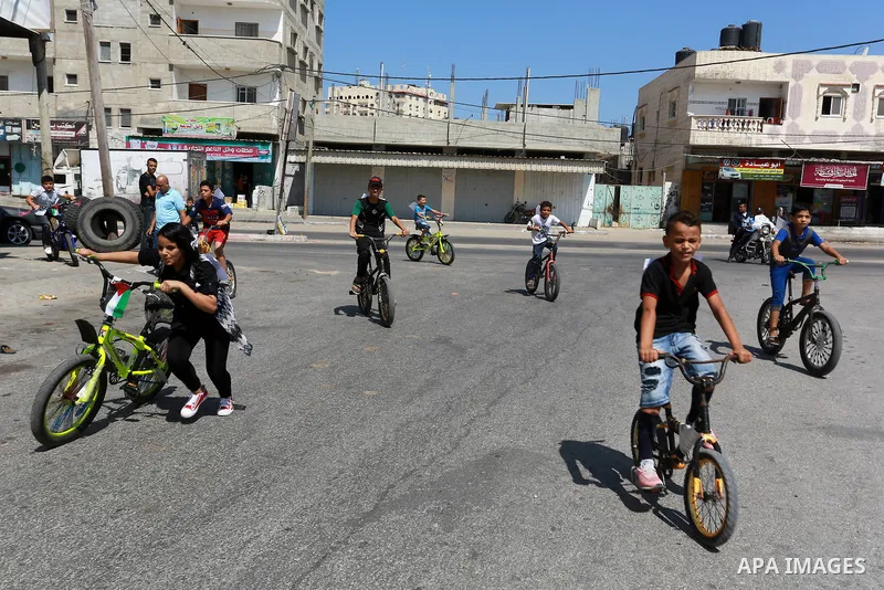 Palestinian children ride bicycles during a marathon in conjunction with a marathon in Britain, Australia, Luton, Birmingham and Coventry to support Palestinian's children and against weapon finance to Israel, in Rafah i...
