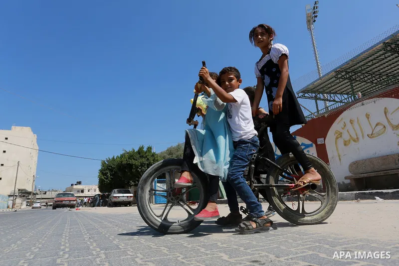 Palestinian children ride bicycles during a marathon in conjunction with a marathon in Britain, Australia, Luton, Birmingham and Coventry to support Palestinian's children and against weapon finance to Israel, in Rafah i...