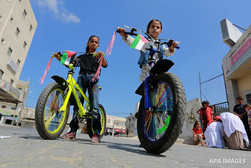 Palestinian children ride bicycles during a marathon in conjunction with a marathon in Britain, Australia, Luton, Birmingham and Coventry to support Palestinian's children and against weapon finance to Israel, in Rafah i...