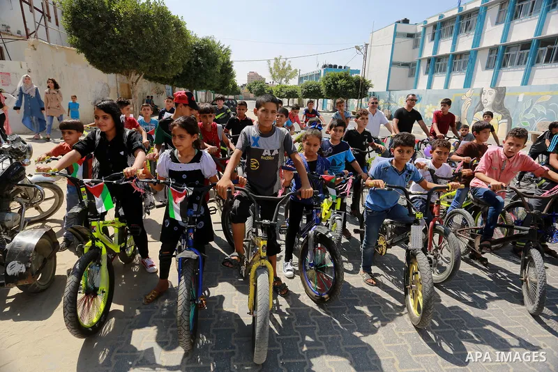 Palestinian children ride bicycles during a marathon in conjunction with a marathon in Britain, Australia, Luton, Birmingham and Coventry to support Palestinian's children and against weapon finance to Israel, in Rafah i...
