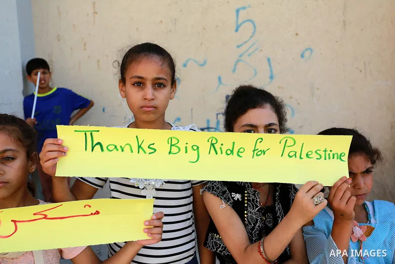 Palestinian children hold placards during a marathon in conjunction with a marathon in Britain, Australia, Luton, Birmingham and Coventry to support Palestinian's children and against weapon finance to Israel, in Rafah i...