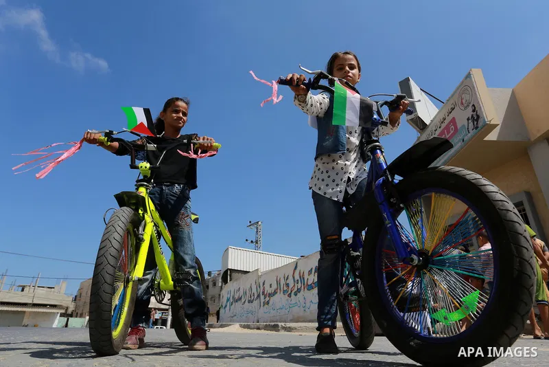 Palestinian children ride bicycles during a marathon in conjunction with a marathon in Britain, Australia, Luton, Birmingham and Coventry to support Palestinian's children and against weapon finance to Israel, in Rafah i...