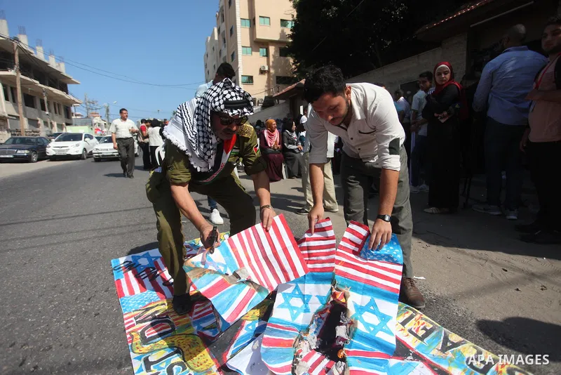 Palestinians burn an Israeli, British and U.S. flags during a protest to show solidarity with Palestinian prisoners held in Israeli jails, in front of Red cross office in Gaza city on August 6, 2018. Photo by Mahmoud Ajo...
