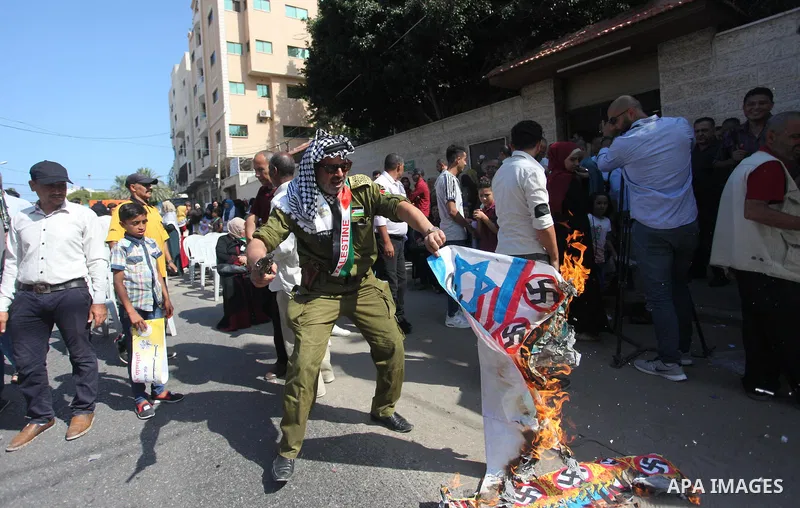 Palestinians burn an Israeli, British and U.S. flags during a protest to show solidarity with Palestinian prisoners held in Israeli jails, in front of Red cross office in Gaza city on August 6, 2018. Photo by Mahmoud Ajo...