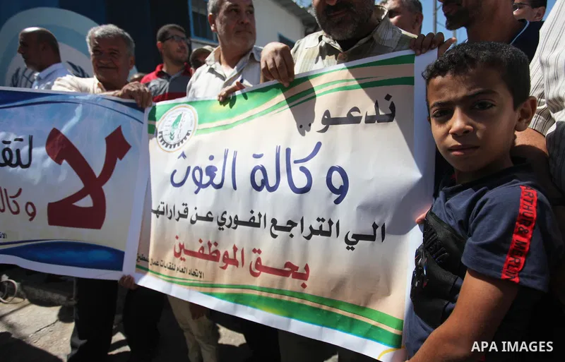 Palestinians hold banners during a protest against a U.S. decision to cut aid, in front of the headquarters United Nations Relief and Works Agency (UNRWA), in Gaza City, on August 6, 2018. Photo by Mahmoud Ajour