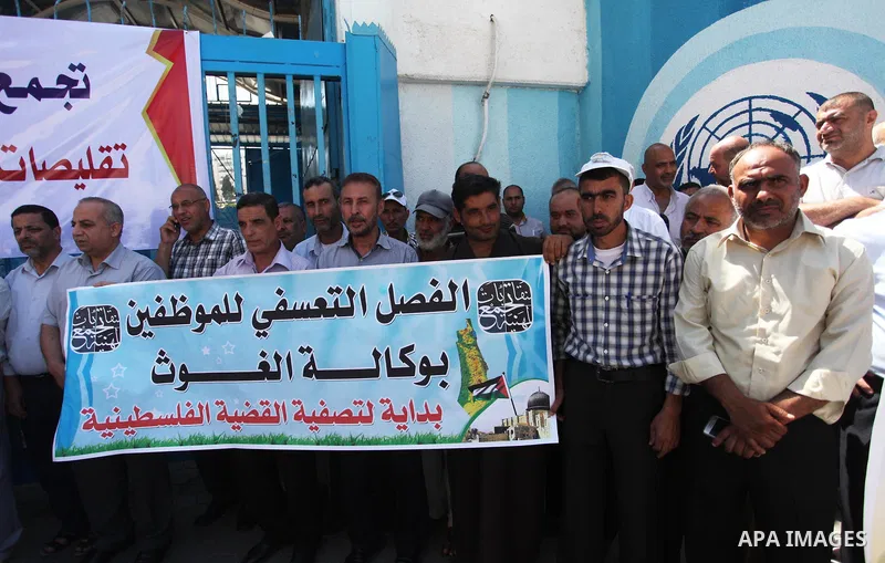 Palestinians hold banners during a protest against a U.S. decision to cut aid, in front of the headquarters United Nations Relief and Works Agency (UNRWA), in Gaza City, on August 6, 2018. Photo by Mahmoud Ajour