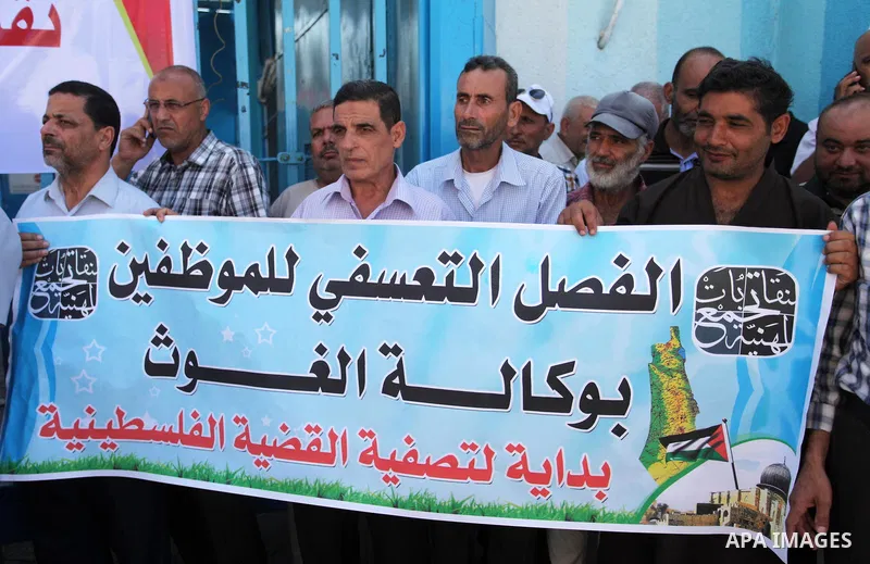 Palestinians hold banners during a protest against a U.S. decision to cut aid, in front of the headquarters United Nations Relief and Works Agency (UNRWA), in Gaza City, on August 6, 2018. Photo by Mahmoud Ajour