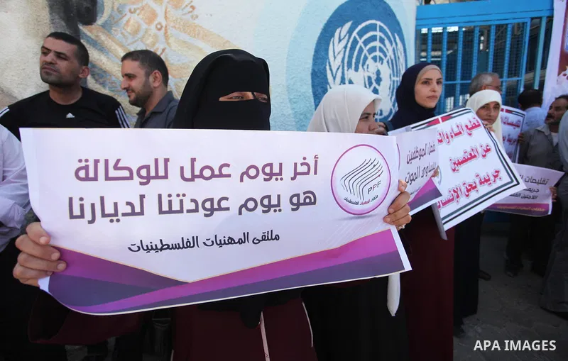 Palestinians hold banners during a protest against a U.S. decision to cut aid, in front of the headquarters United Nations Relief and Works Agency (UNRWA), in Gaza City, on August 6, 2018. Photo by Mahmoud Ajour