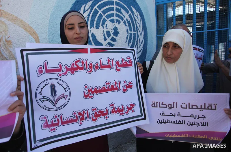 Palestinians hold banners during a protest against a U.S. decision to cut aid, in front of the headquarters United Nations Relief and Works Agency (UNRWA), in Gaza City, on August 6, 2018. Photo by Mahmoud Ajour