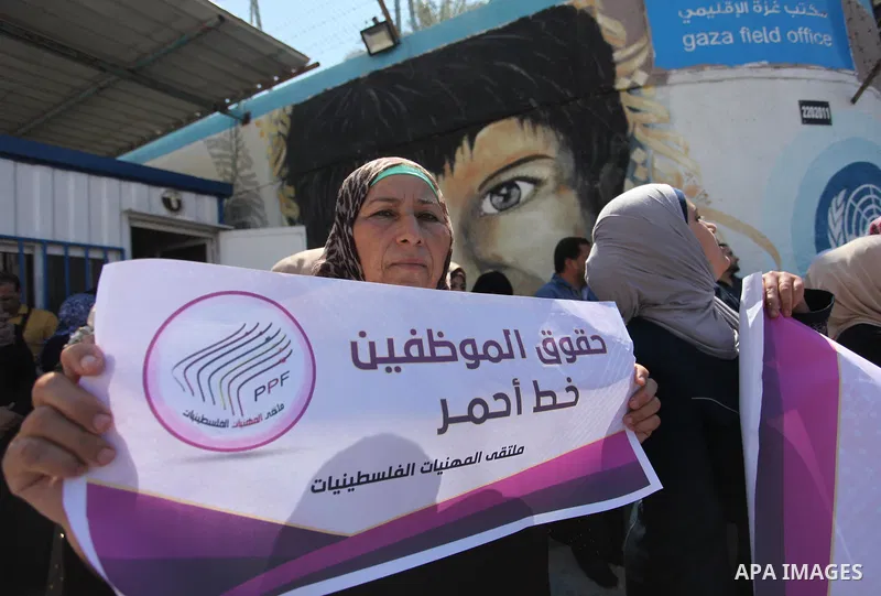 Palestinians hold banners during a protest against a U.S. decision to cut aid, in front of the headquarters United Nations Relief and Works Agency (UNRWA), in Gaza City, on August 6, 2018. Photo by Mahmoud Ajour