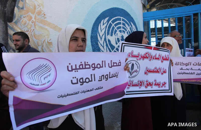 Palestinians hold banners during a protest against a U.S. decision to cut aid, in front of the headquarters United Nations Relief and Works Agency (UNRWA), in Gaza City, on August 6, 2018. Photo by Mahmoud Ajour
