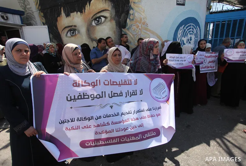 Palestinians hold banners during a protest against a U.S. decision to cut aid, in front of the headquarters United Nations Relief and Works Agency (UNRWA), in Gaza City, on August 6, 2018. Photo by Mahmoud Ajour