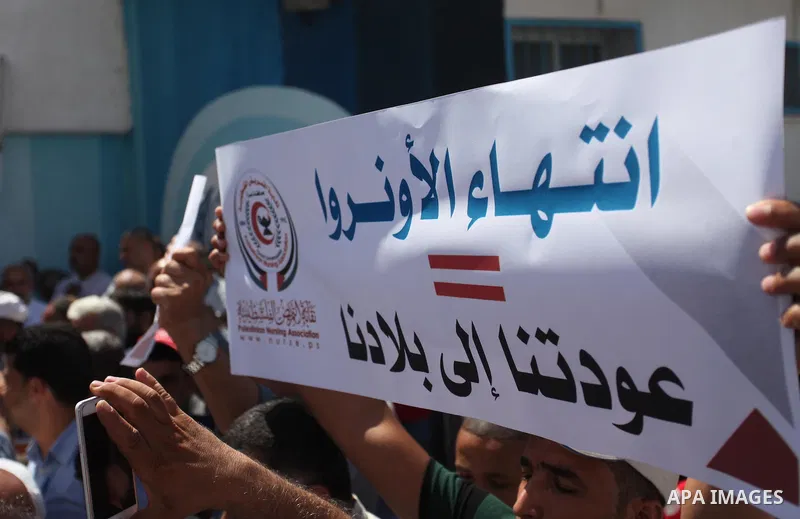 Palestinians hold banners during a protest against a U.S. decision to cut aid, in front of the headquarters United Nations Relief and Works Agency (UNRWA), in Gaza City, on August 6, 2018. Photo by Mahmoud Ajour