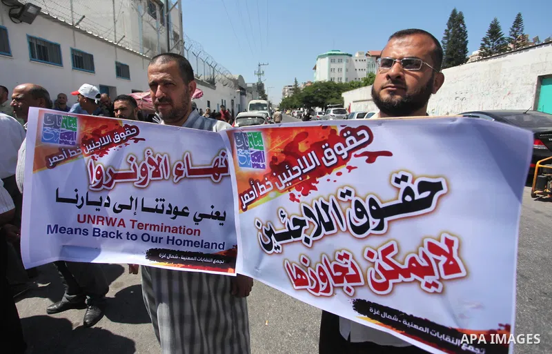 Palestinians hold banners during a protest against a U.S. decision to cut aid, in front of the headquarters United Nations Relief and Works Agency (UNRWA), in Gaza City, on August 6, 2018. Photo by Mahmoud Ajour